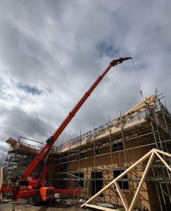 Mini crane on construction site with roof truss