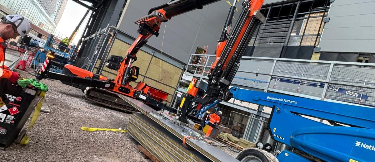 Mini crane lifting on a busy construction site